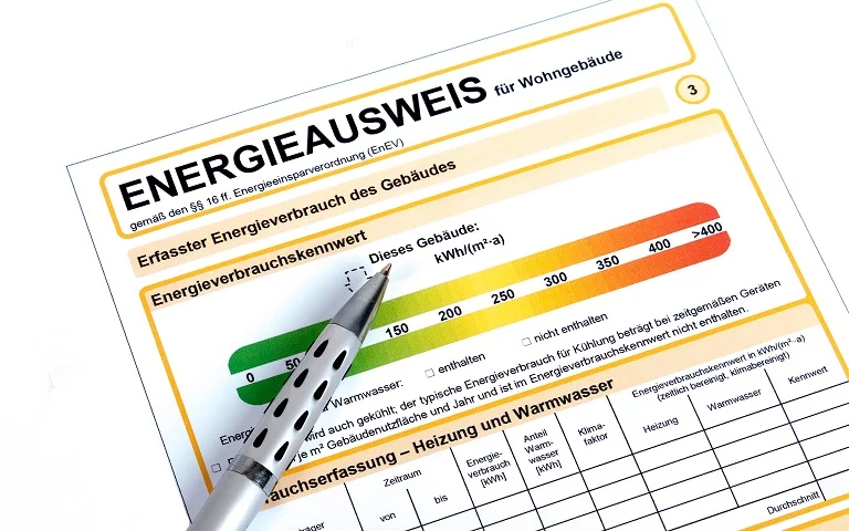 Energieausweis-Formular für Wohngebäude mit darüberliegendem Kugelschreiber