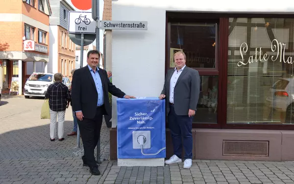 Dr. Christoph Meier (links) und Rodgaus Bürgermeister Max Breitenbach mit Stromkasten in neuem Design