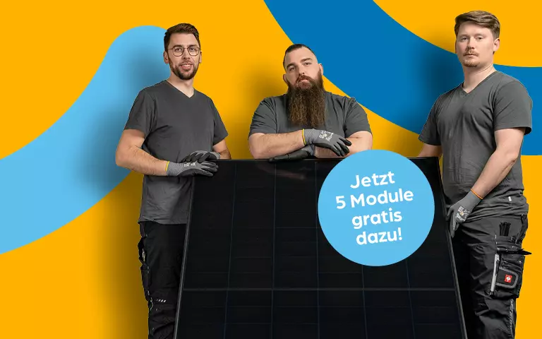 Drei Personen in grauen Shirts und Handschuhen halten ein großes Solarpanel. Ein blauer Kreis mit weißer Schrift zeigt den Angebots-Text "Jetzt 5 Module gratis dazu!"