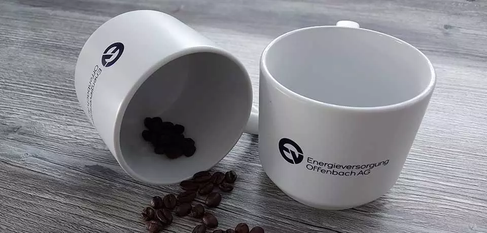 Tassen mit EVO-Logo und Kaffeebohnen