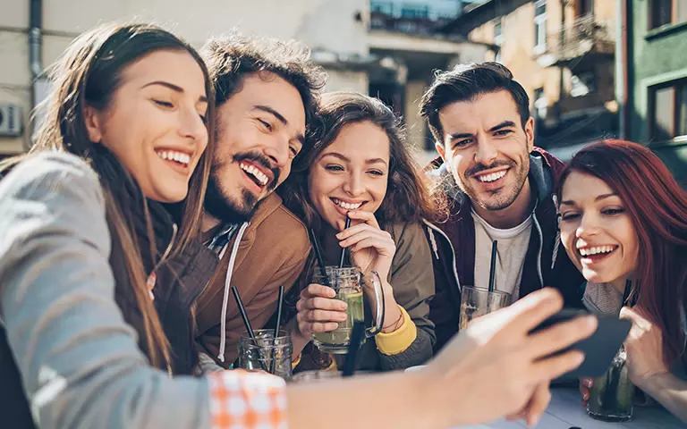 Gruppe von Menschen schaut auf ein Smartphone