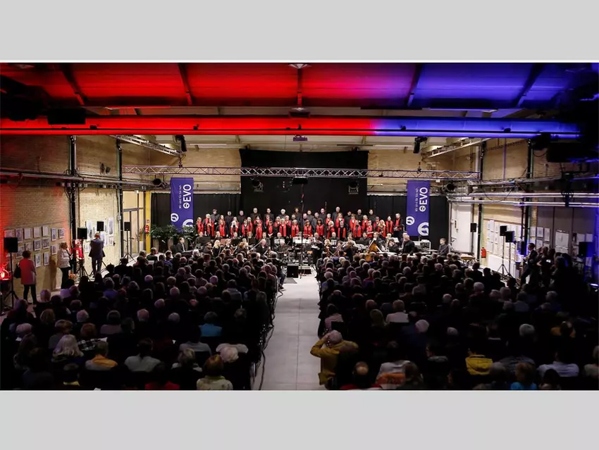 Chor und Orchester auf der Bühne vor Publikum