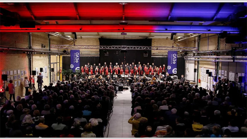 Chor und Orchester auf der Bühne vor Publikum